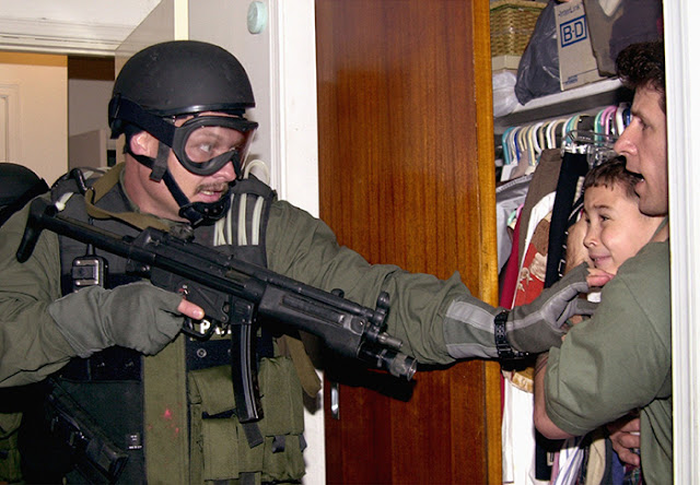 Armed federal agent seizes Elián González from his relatives' home in Miami, April 22, 2000